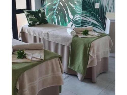 a table with two tables with green tablecloths at Penthouse Suite, Exquisite One Bedroom Apartment in Ballito