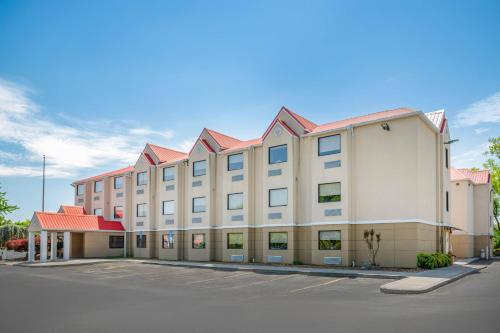 a large white building with a red roof at Quality Inn Knoxville West Cedar Bluff in Knoxville