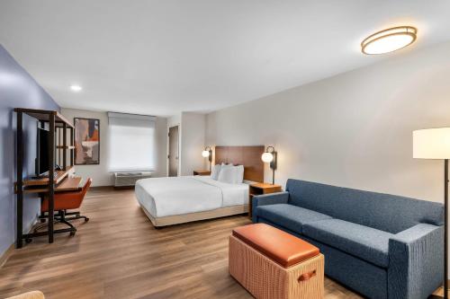 a hotel room with a bed and a couch at Everhome Suites Stockbridge Atlanta in Stockbridge