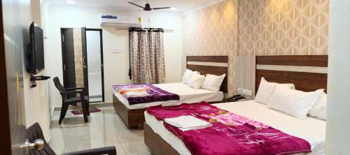 a hotel room with two beds and a television at HoTEL SRI DURGA GRAND in Vijayawāda