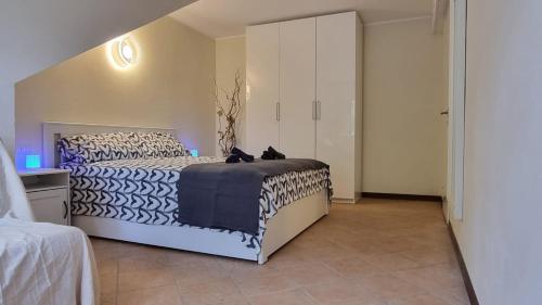 a bedroom with a bed with black and white sheets at Casa Mariangela pool and garden in Leggiuno