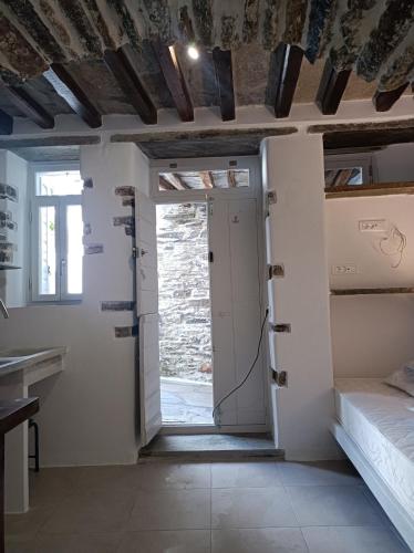 a room with a door and a bed and a window at Μαγαζάκι in Tripótamos
