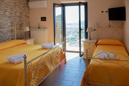 two beds in a room with a balcony at B&B MALVETUM in Malvito