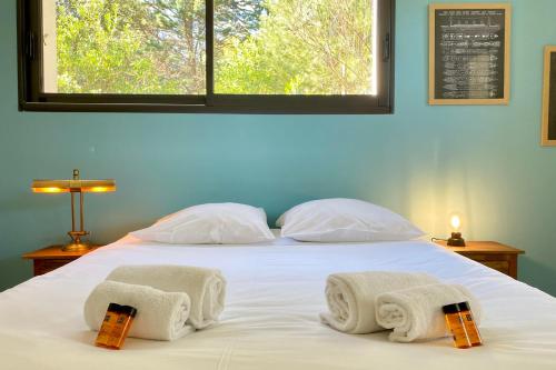 a bedroom with a bed with towels on it at Villa des Dunes Beach 600m Private Jacuzzi Pine Forest Nature Sleeps 8 in Brem-sur-Mer