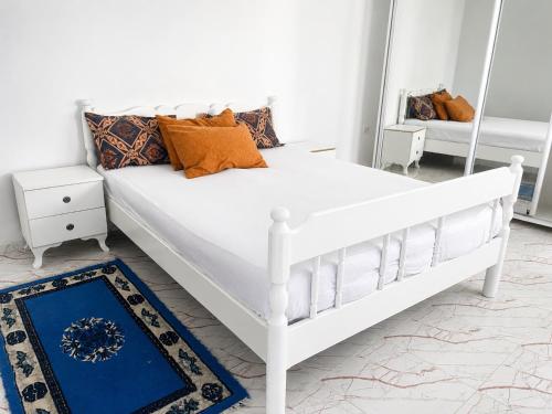 a white bed in a room with a mirror at Cozy Retreat in Bou Ficha
