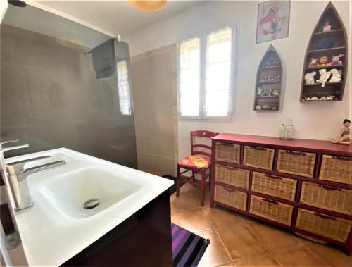 a bathroom with a white sink and a red counter at Villa Aghjanella in Patrimonio
