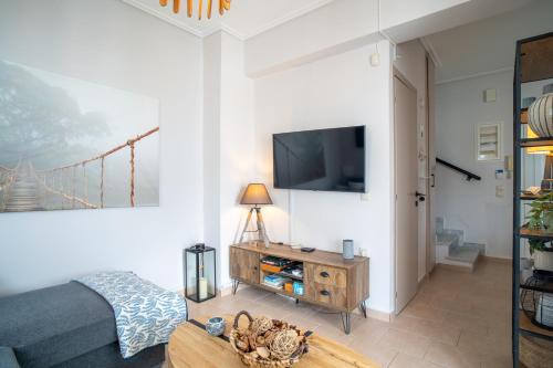 a living room with a couch and a tv at Phoebes Place At Kalamaki Court, 2 Bedroom Villa With A Shared Pool - Fully Refurbished For 2026 in Kalamaki