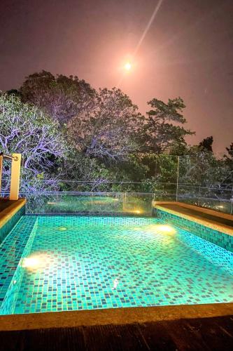 a swimming pool with lights in the night at Lighthouse Point Hotel in Dumaguete