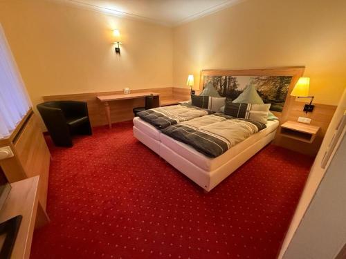 ein Schlafzimmer mit einem großen Bett und einem roten Teppich in der Unterkunft Hotel Zum Kellermann in Grafenau