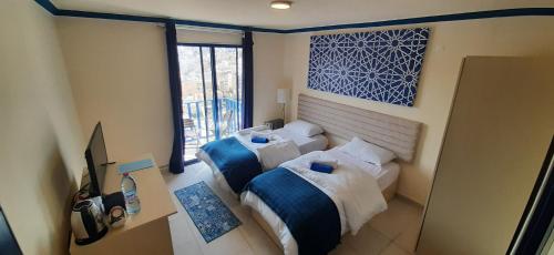 two beds in a small room with a window at Citadel Boutique Hotel in Amman