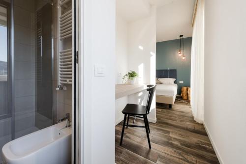 a bathroom with a tub and a sink and a chair at Locanda la Cross - Adults Only in Garda