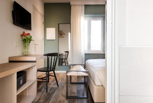 ein Schlafzimmer mit einem Bett und einem Schreibtisch mit einem Stuhl in der Unterkunft Locanda la Cross - Adults Only in Garda