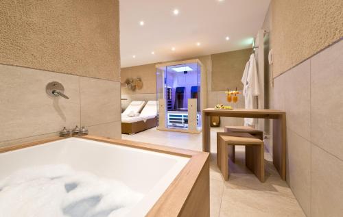 a bathroom with a bath tub and a bedroom at Ringhotel Am Stadtpark in Lünen