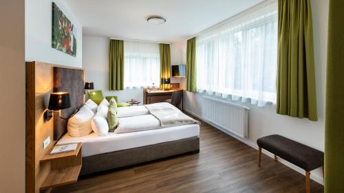 a hotel room with a bed and a window at Schnitzers Dahoam - Hundefreundlich in Bad Wiessee