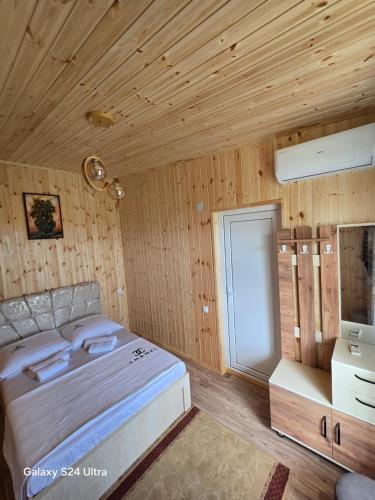a bedroom with a large bed and wooden walls at VILLA TAMARISI in Rokit'i