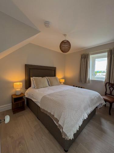a bedroom with a large bed with two lamps at Westfield Barn in Cashel