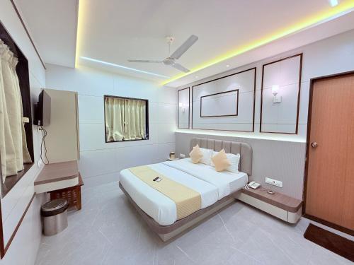 a bedroom with a bed and a tv in it at Hotel Le Glance Rooms & Dormitory in Mumbai
