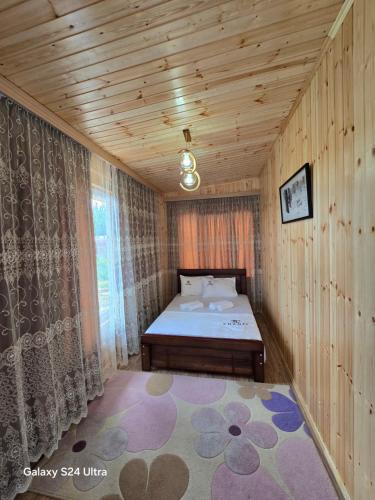 a small bedroom with a bed and a wooden ceiling at VILLA TAMARISI in Rokit'i