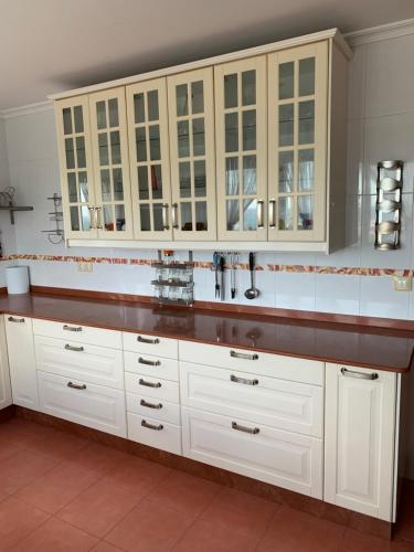 a kitchen with white cabinets and a sink at Chalet unifamiliar Foz-Nois in Barrosa