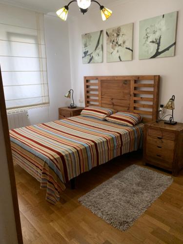 a bedroom with a large bed with a striped blanket at Chalet unifamiliar Foz-Nois in Barrosa