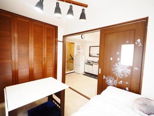 a bedroom with a mirror and a bed and a kitchen at Miyabi Stay Tokyo in Kamatachō