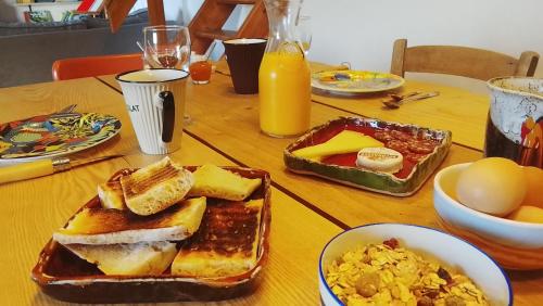 a table with a breakfast of bread and eggs at Marmite et traversin in Cénevières