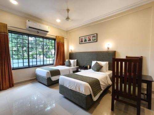 a hotel room with two beds and a window at HOTEL SAHANA CASTLE in Nāgercoil