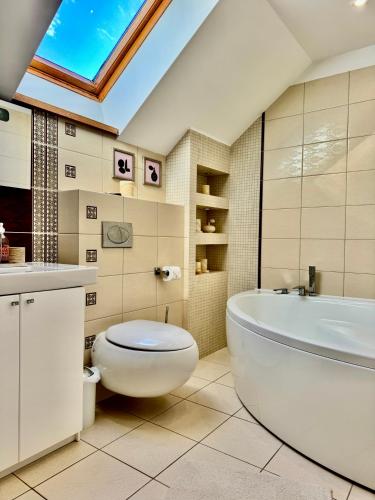 a bathroom with a toilet and a tub and a sink at Sodyba prie jūros in Palanga