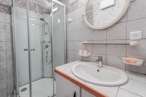 a bathroom with a sink and a shower and a mirror at Chalet à Aulus-Les-Bains in Aulus-les-Bains