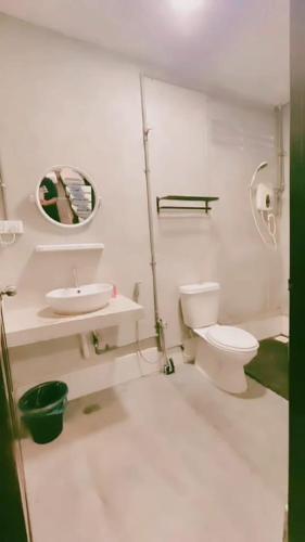 a white bathroom with a toilet and a sink at Pirate's Cove in Malacca