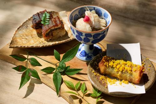 a table with two plates of food and a bowl of ice cream at Ochiairo in Izu