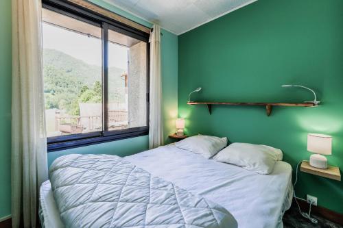 a bedroom with a bed and a large window at Chalet à Aulus-Les-Bains in Aulus-les-Bains