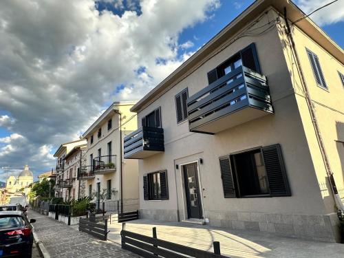 ein weißes Gebäude mit Balkonen an einer Stadtstraße in der Unterkunft SottoStelle in Santa Maria degli Angeli