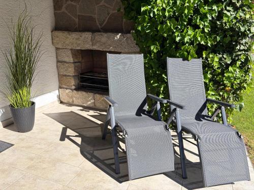 two chairs sitting in front of a fireplace at Ferienwohnung Ottenzeller Haisl in Arrach