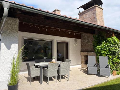 a patio with a table and chairs and a fireplace at Ferienwohnung Ottenzeller Haisl in Arrach
