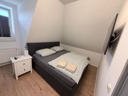 a small bedroom with a bed with two towels on it at Gemütliche Ferienwohung in Neubrandenburg