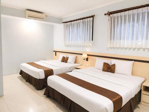 a hotel room with two beds in a room at Scarlet Hotel Stasiun Bandung in Bandung