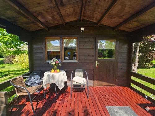 a porch of a cabin with a table and chairs at Cozy Summer House with Free Parking near Town Center & Beach in Kuressaare