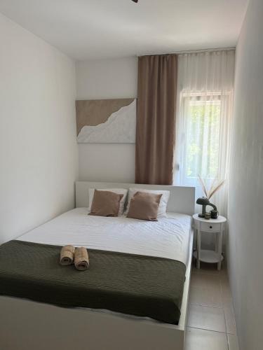 a bedroom with a bed with two shoes on it at Apartman Magdalena in Budva