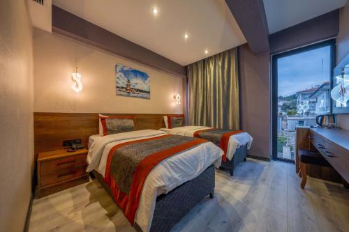 a hotel room with two beds and a window at Ornella Butik Otel in Edremit
