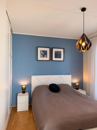 a bedroom with a bed with a blue wall at River Apartment in Pärnu