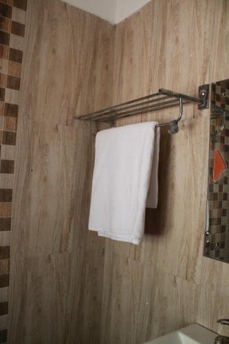 a bathroom with a white towel hanging on a wall at Palash Baag in Jodhpur