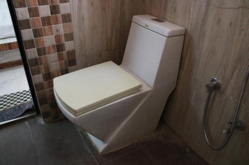 a white toilet in a bathroom with a shower at Palash Baag in Jodhpur
