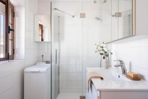 a white bathroom with a shower and a sink at Casa Pueblo Lopez in Fuengirola