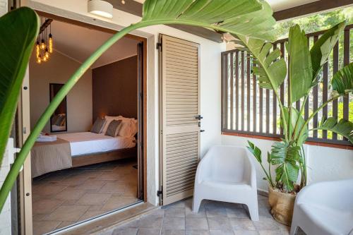 a bedroom with a bed and a chair and a plant at La Ginestra in Fiore Camere in Sirolo