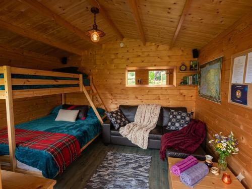a bedroom with a bed and a couch in a cabin at Cozy Summer House with Free Parking near Town Center & Beach in Kuressaare