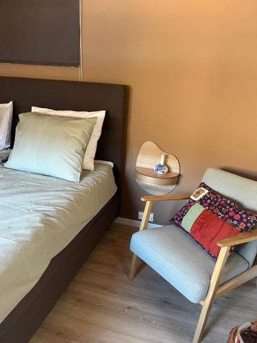 a bed and a chair in a room at Le Son des Violons in Sallèles-dʼAude