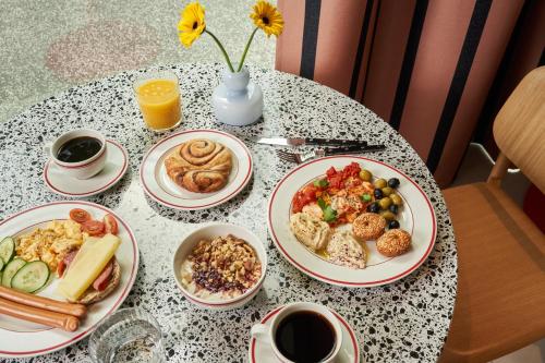 a table with plates of breakfast food on it at Numa Hamburg St Georg in Hamburg