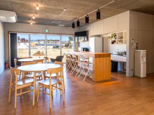 a kitchen and dining room with tables and chairs at cocomio in Bungoono