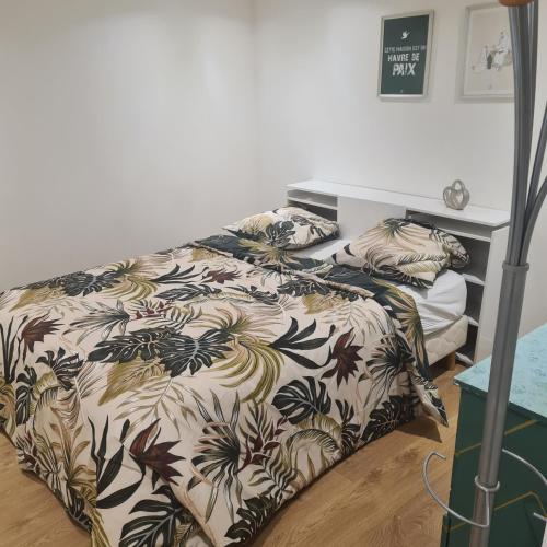 a bedroom with two beds with a bedspread with flowers at Appart T2 indépendant in Dammarie-lès-Lys